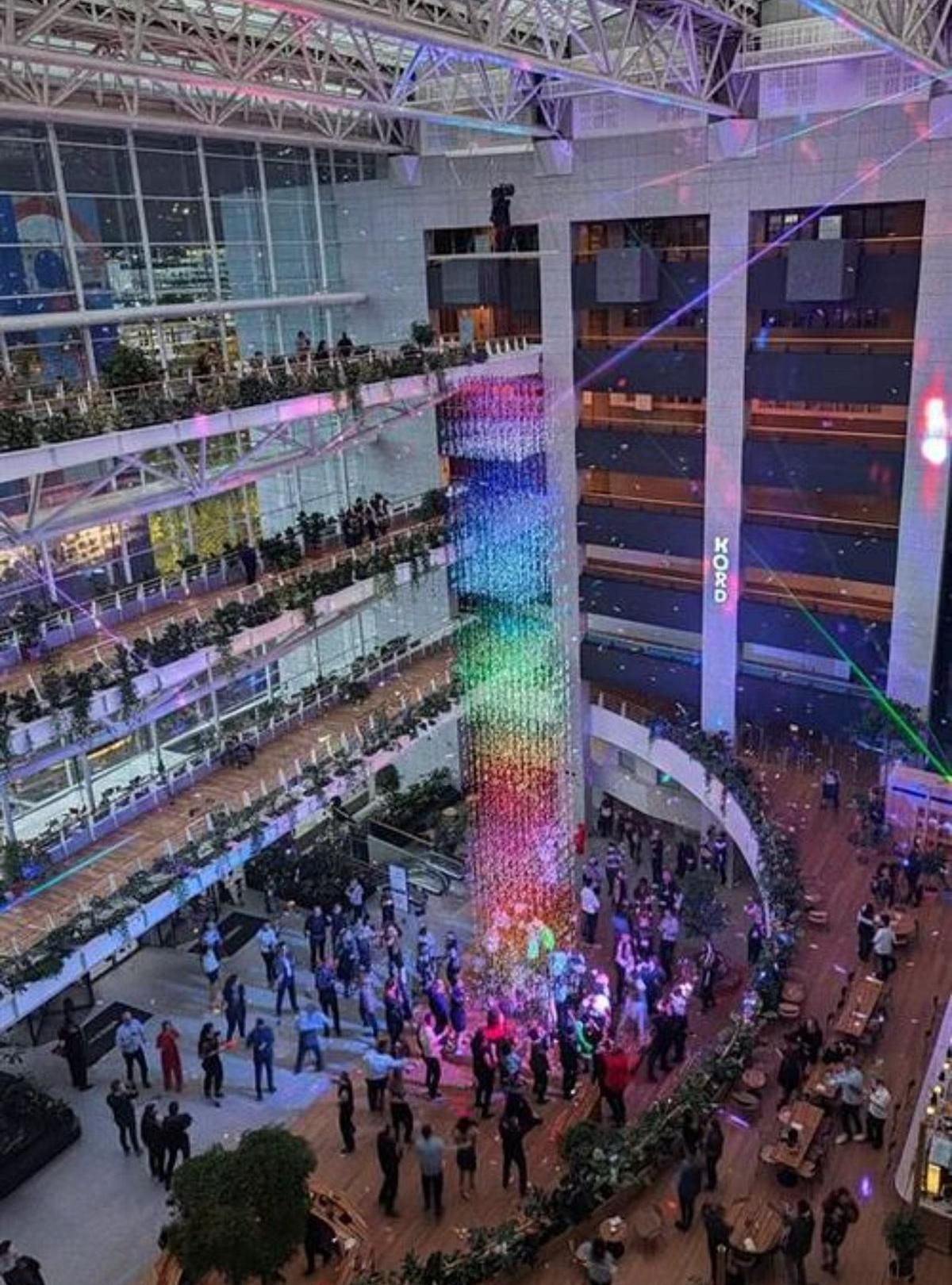 Vue plongeante sur l'atrium du bâtiment Lumière illuminé, le public en contrebas