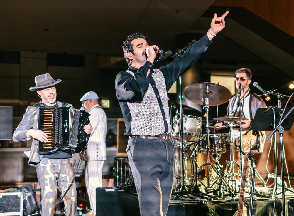 Groupe de musique sur scène, chanteur et accordéoniste