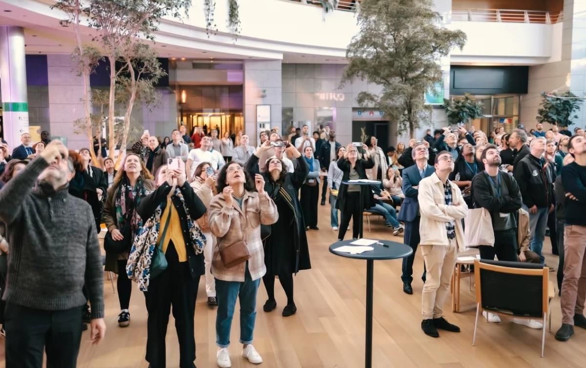 Les occupants rassemblés dans le hall, les yeux levés vers la danse aérienne