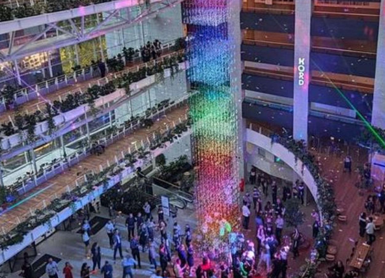 Atrium illuminé aux couleurs de l'arc-en-ciel pendant une soirée