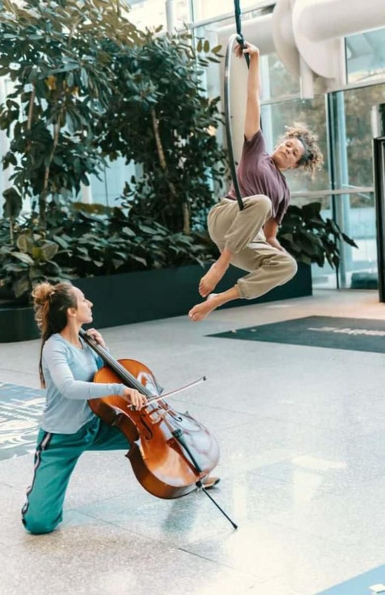 Danseuse aérienne et violoncelliste dans l'atrium du bâtiment Lumière
